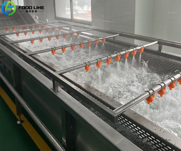 High-pressure spray nozzles washing produce in bubble tank